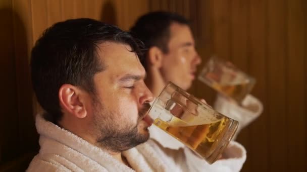 Mannen ontspannen in het bad, de sauna, het drinken bier — Stockvideo