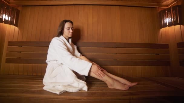 Rest van de jonge vrouw in de sauna — Stockvideo