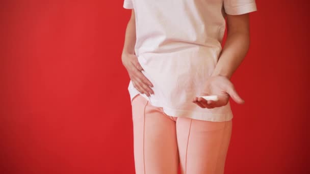 月经的概念, 女孩排卵。女孩在红色背景拿着卫生棉条, 垫片. — 图库视频影像
