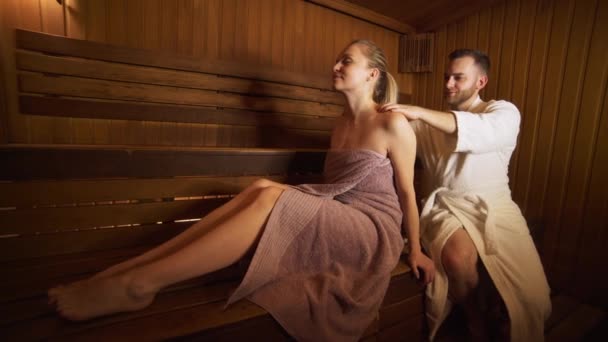 Un homme fait un massage du dos et du cou belle femme dans le sauna, bain . — Video