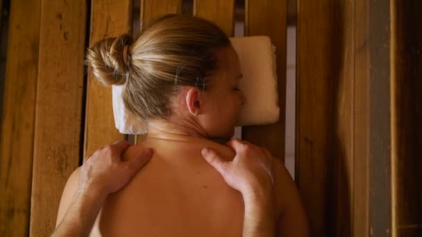 Człowiek czyni pleców i szyi, masaż piękna kobieta w saunie, łaźni. — Wideo stockowe