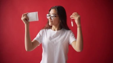 Regl, yumurtlama kızlarda kavramı. Kız bir tampon tutan bir kırmızı zemin üzerine conta.