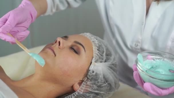 В клинике красоты. Женщине делают косметическую косметологию лица . — стоковое видео