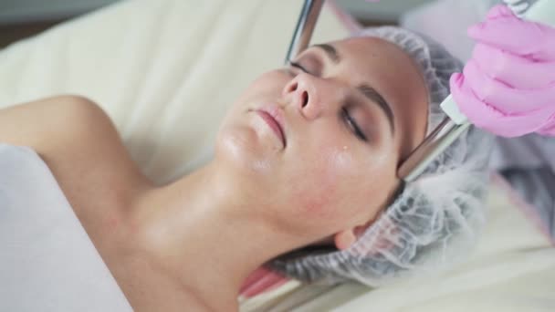 Clínica de beleza. Uma mulher recebe beleza procedimento de cosmetologia facial . — Vídeo de Stock