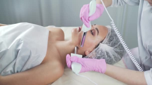 Schoonheid kliniek. Een vrouw krijgt schoonheid gezicht cosmetologie procedure. — Stockvideo