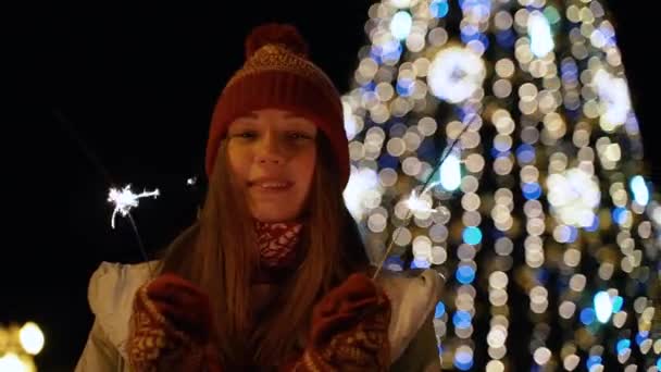 Una muchacha sostiene un frente ligero de Bengala al árbol de Navidad — Vídeos de Stock