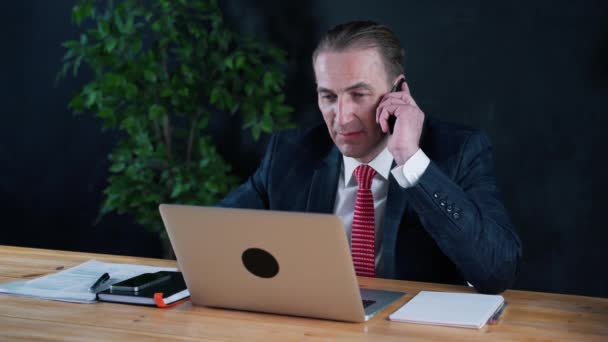 Homme d'affaires ou avocat assis au travail devant un ordinateur portable . — Video