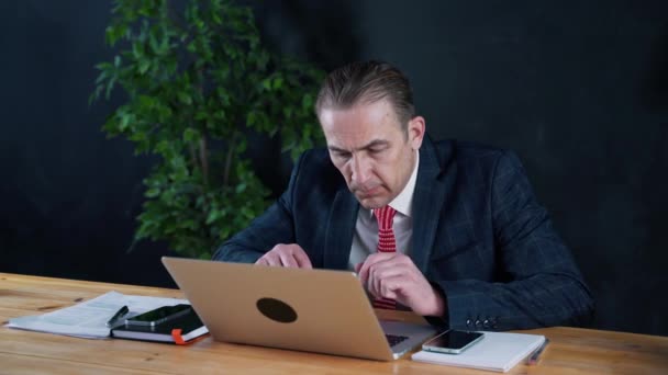 Mann Geschäftsmann oder Anwalt sitzt bei der Arbeit vor einem Laptop. — Stockvideo