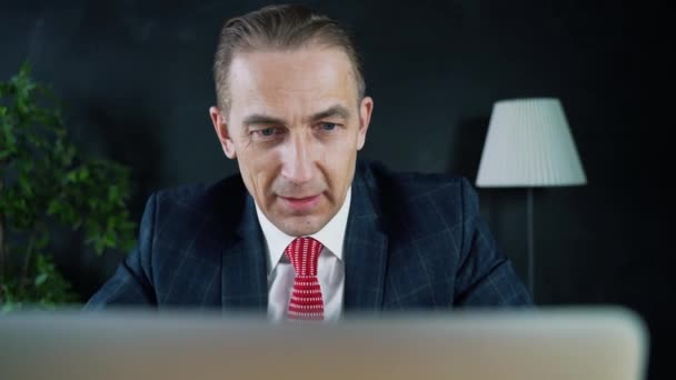 Mann Geschäftsmann oder Anwalt sitzt bei der Arbeit vor einem Laptop. — Stockvideo