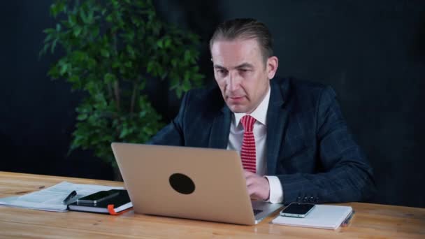 Üzletember vagy ügyvéd dolgozik az irodában, egy laptop — Stock videók