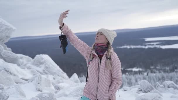 En flicka tar en selfie i bergen. — Stockvideo