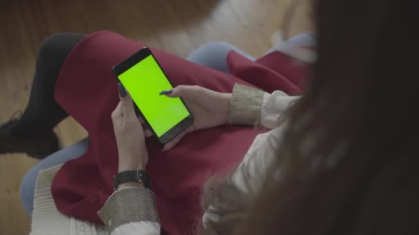 Hermosa chica sosteniendo un teléfono inteligente en las manos de una pantalla verde pantalla verde. — Vídeos de Stock