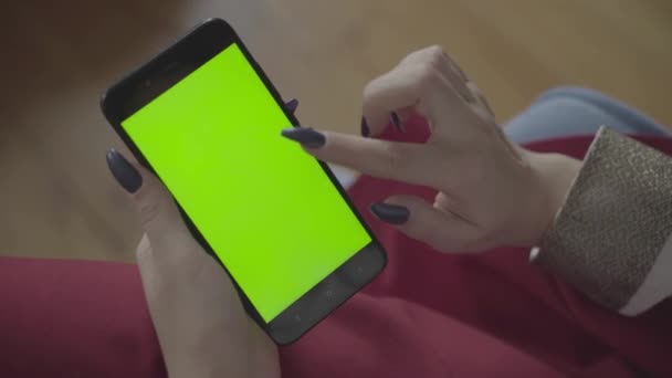 Menina bonita segurando um smartphone nas mãos de uma tela verde tela verde. — Vídeo de Stock