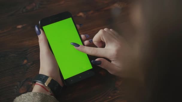 Kaunis tyttö, jolla on älypuhelin vihreän ruudun vihreässä näytössä. — kuvapankkivideo
