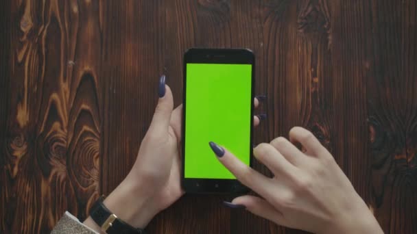 Menina bonita segurando um smartphone nas mãos de uma tela verde tela verde. — Vídeo de Stock