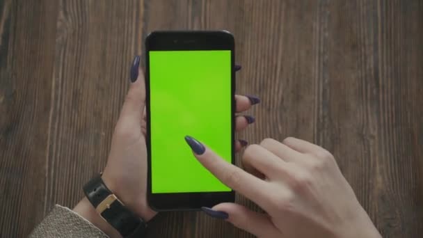 Belle fille tenant un smartphone dans les mains d'un écran vert écran vert. — Video