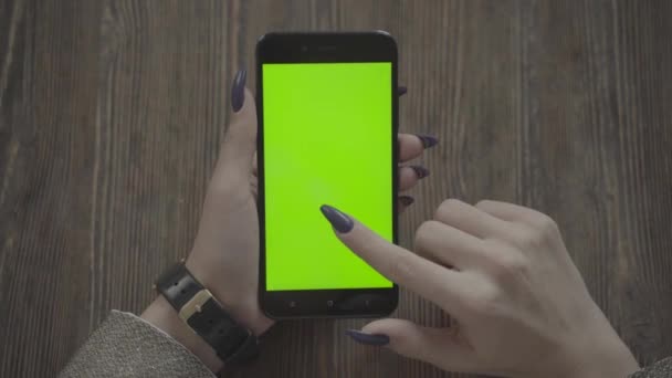 Belle fille tenant un smartphone dans les mains d'un écran vert écran vert. — Video