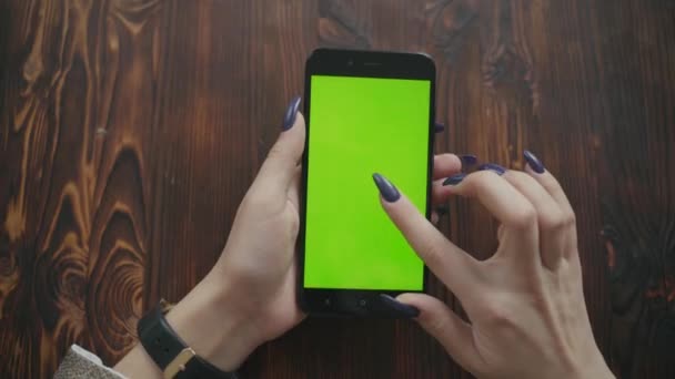 Pantalla verde. Sobre el hombro de la joven mujer caucásica con el pelo largo y negro usando el teléfono móvil con croma key — Vídeos de Stock