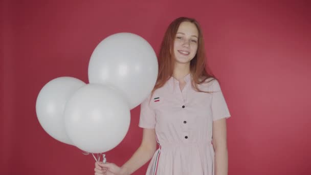 Cumpleaños, concepto de San Valentín. Chica feliz sosteniendo un montón de globos sobre un fondo rojo, la chica es feliz — Vídeo de stock