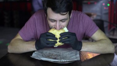 bir barda bir Burger yeme aç adam.
