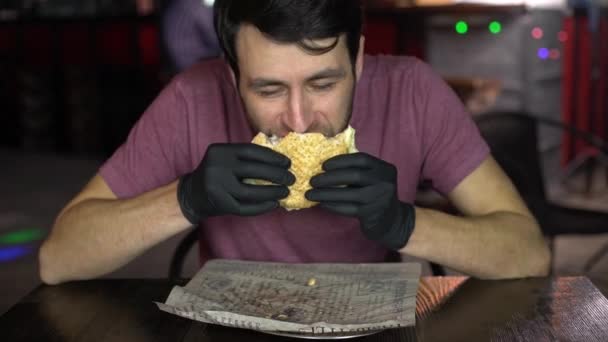 Hladový muž v baru, který žere Burger. — Stock video