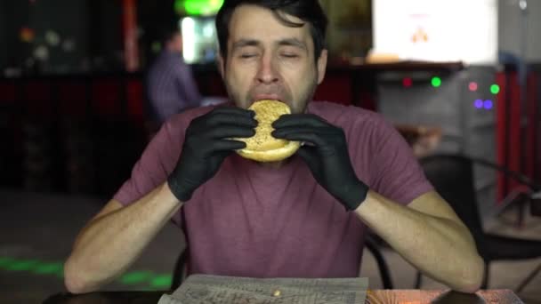 Homme affamé dans un bar manger un hamburger . — Video