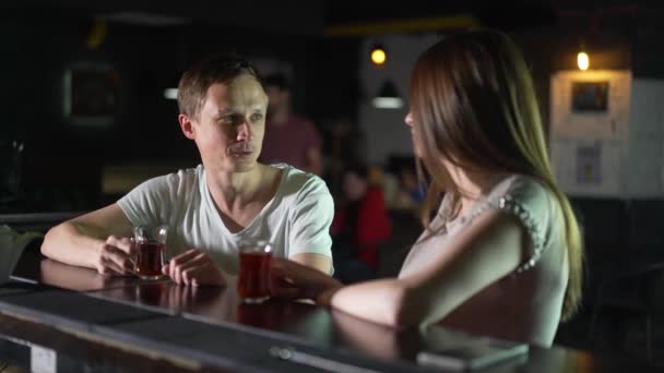 La chica y el tipo están sentados en el bar, charlando. Hombre tratando de recoger a una mujer en el bar — Vídeos de Stock