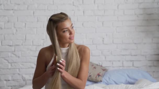 Женщина расчесывает длинные каштановые волосы — стоковое видео