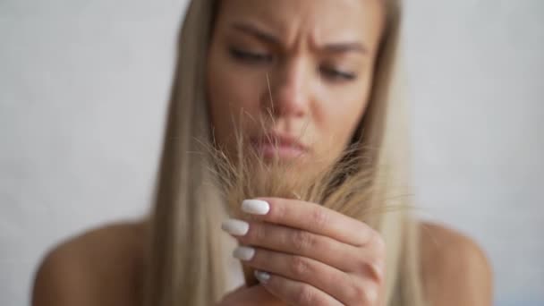 Vrouw ziet er desprately aan gespleten haar uiteinden na het douchen. — Stockvideo