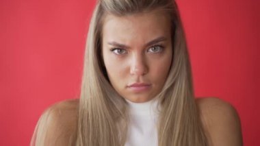Kızgın kadın yüz ifadesi. Kırgın. Üzgün model yüzün yakın. Üzgün kız yüz ifadesi. Beyaz arka planda kameraya bakan mutsuz kadının portresi. Olumsuz kadın duygu.