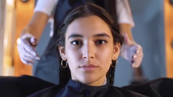 미용사, 스타일리스트는 여성 클라이언트의 머리를 빗질하고 전문 헤어 살롱에서 머리를 고정하기위한 barrette를 사용하여. 뷰티 및 헤어케어 컨셉. — 비디오