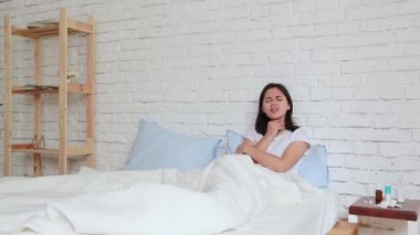 Yatakta yatan, peçetede hapşıran ve kötü bir soğuk algınlığı olan genç kadın rahatsız. Kapalı