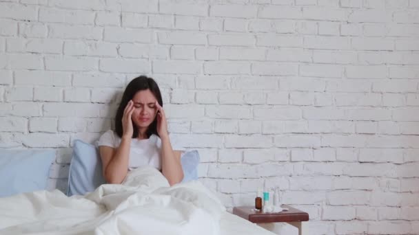 Unwell ung kvinna som ligger i sängen, nysningar i servetten och har en dålig förkylning. Inomhus — Stockvideo