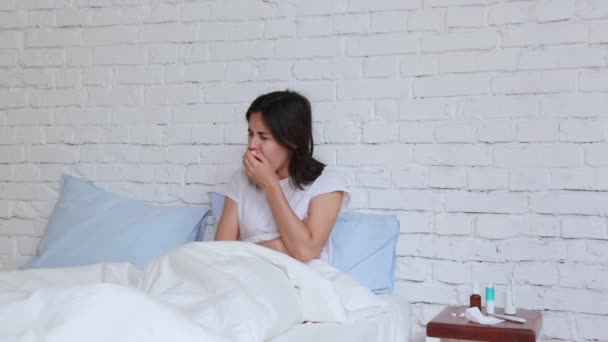 Yatakta yatan, peçetede hapşıran ve kötü bir soğuk algınlığı olan genç kadın rahatsız. Kapalı — Stok video