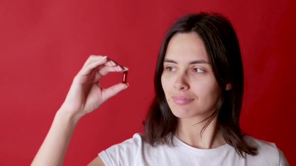Close-up shot van een hand vasthouden kleur pillen op de achtergrond — Stockvideo