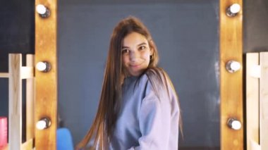 Bir güzellik salonunda bir Botox prosedürü sonra genç bir kadının güzel temiz bakımlı saç. Kız sonuçtan memnun, aynaya karşı.