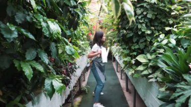 Serada dans eden önlükte güzel bir kız. Çiçekçi mutlu, dans ve gülme.