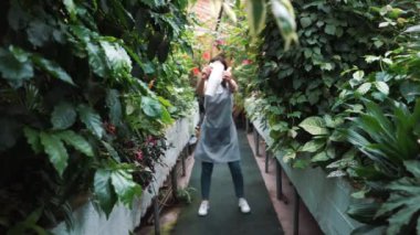 Serada dans eden önlükte güzel bir kız. Çiçekçi mutlu, dans ve gülme.