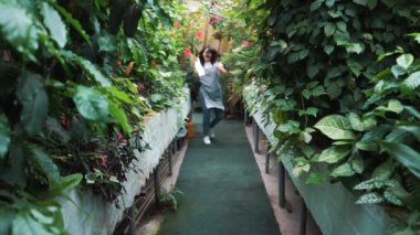 Serada dans eden önlükte güzel bir kız. Çiçekçi mutlu, dans ve gülme.