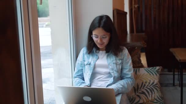 Piękna kobieta siedzi z przenośnym NET-Book w nowoczesnej kawiarni bar, młody uroczy żeński Freelancer — Wideo stockowe