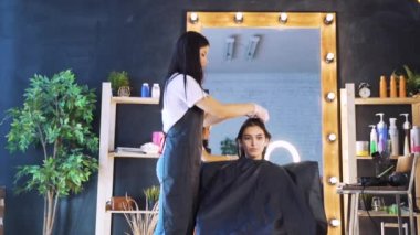 Kuaförlü bir güzellik salonunda bir kız. Salonda saç bakımı kavramı, keratin, saç düzleştirme.