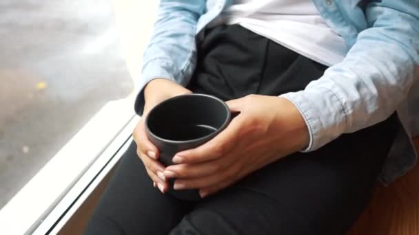 Brünette Frau trinkt Kaffee am Fenster — Stockvideo