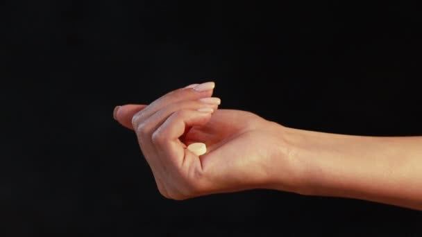 Close-up shot van een hand vasthouden kleur pillen op de achtergrond — Stockvideo