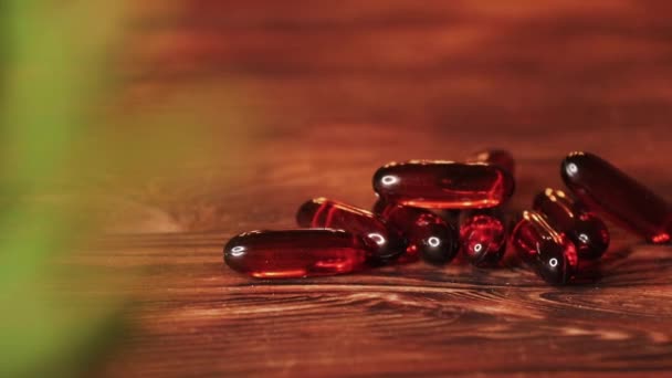 Βιταμίνες Συμπληρώματα χάπια ωμέγα 3. Φάρμακα συκωτιού γάδου σε ξύλινο τραπέζι. Κάψουλες ιχθυελαίου — Αρχείο Βίντεο