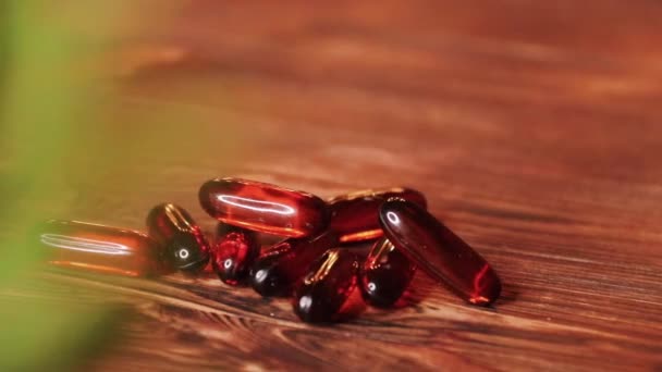 Vitaminok kiegészítők tabletták Omega-3. Csukamájolaj gyógyszerek a fából készült asztal. Halolaj kapszula — Stock videók