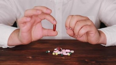 Doktor bir yığın dağınık olanlardan bir hap seçer. Bağımlısı bir hap seçer. Tabletler masaya dağılmış.