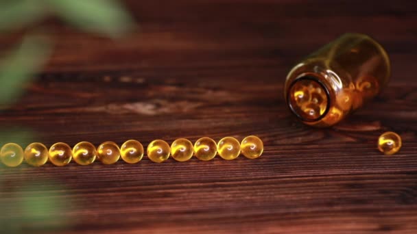 Vitaminas suplementos comprimidos ômega 3. Medicamentos de óleo de fígado de bacalhau na mesa de madeira. Cápsulas de óleo — Vídeo de Stock
