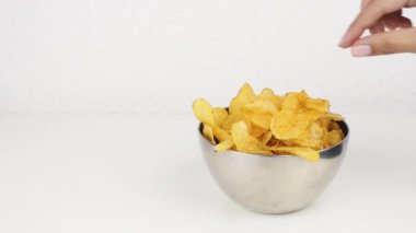 Derin bir tabak patates cipsi almak ile Kadın güzel eller. Sağlıksız gıda, fast food