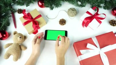 Ahşap arka plan. Üst te. Noel tatili dekorasyonu ile masada yatan yeşil ekranlı siyah akıllı telefon.