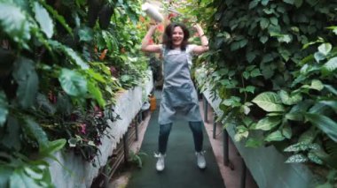 Serada dans eden önlükte güzel bir kız. Çiçekçi mutlu, dans ve gülme.